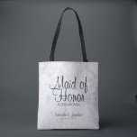 White Reflections Wedding Maid of Honour Tote Bag<br><div class="desc">This beautiful tote bag is perfect for thanking your Maid of Honour. It features black text over a background of reflecting white peony flowers and hearts. The text is fully customisable and reads: Maid of Honour, with a place for her name, the couple's names and wedding date. Perfect for filling...</div>