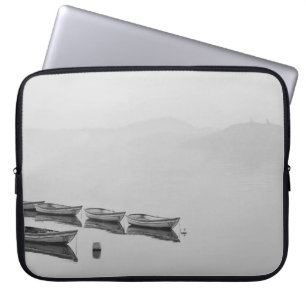 WHITE ROW BOATS INLINE ON BODY OF WATER DURING FOG LAPTOP SLEEVE