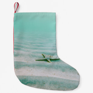 White starfish on sand underwater in the morning small christmas stocking