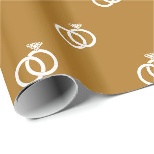 White Wedding Rings on Matte Gold Wrapping Paper