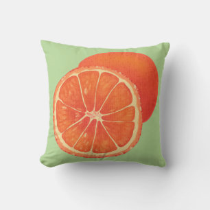 Whole Orange and Sliced Oranges on Green Pillows