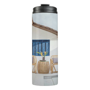 Wicker table and two chairs near swimming pool thermal tumbler