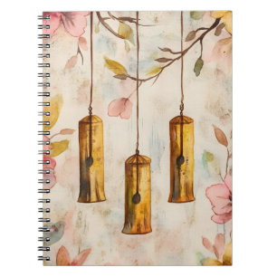 Wind chimes suspended from a flowering branch. notebook