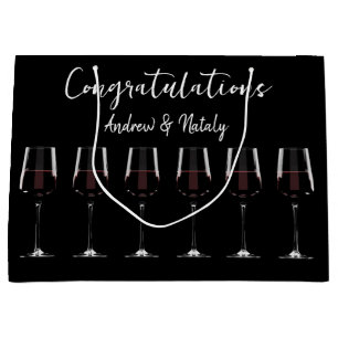 Wine glasses with red wine on black large gift bag
