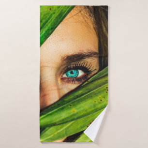 Woman behind green leaves bath towel