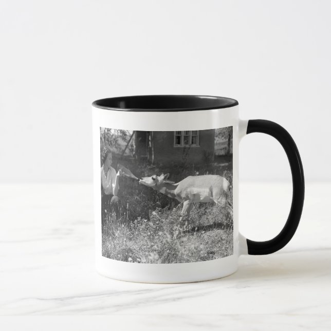 Woman bottle feeding an antelope. mug (Right)