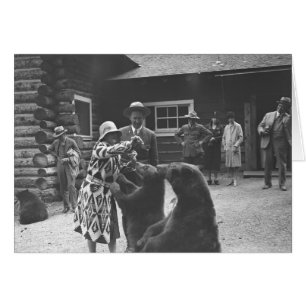 Woman feeding bears with a group of people in fron