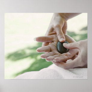 Woman getting hand massage with hot stone poster
