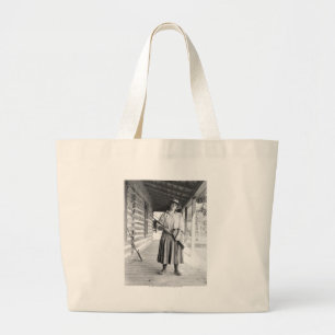 Woman holding a rifle on a porch large tote bag