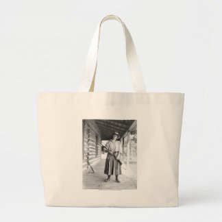 Woman holding a rifle on a porch large tote bag