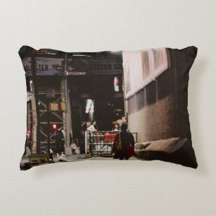 WOMAN IN BLACK AND RED DRESS WALKING BESIDE BROWN DECORATIVE CUSHION
