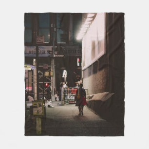 WOMAN IN BLACK AND RED DRESS WALKING BESIDE BROWN FLEECE BLANKET