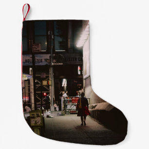 WOMAN IN BLACK AND RED DRESS WALKING BESIDE BROWN  SMALL CHRISTMAS STOCKING