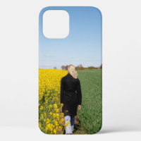 Woman in black coat standing on green grass field 