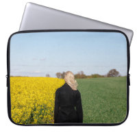 Woman in black coat standing on green grass field