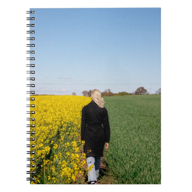 Woman in black coat standing on green grass field  notebook (Front)