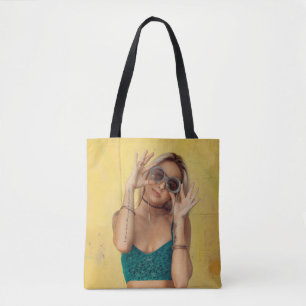 Woman in blue bralette holding sunglasses putting tote bag
