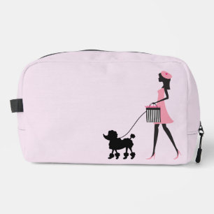 Woman in pink walking black poodle dopp kit