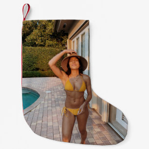 Woman in yellow bikini standing on brown brick flo small christmas stocking