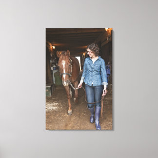 Woman leading horse canvas print