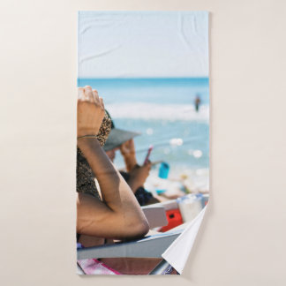 Woman lying on sun lounger covering her face with  bath towel
