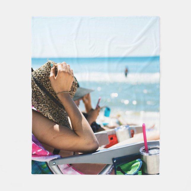 Woman lying on sun lounger covering her face with  fleece blanket (Front)