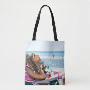 Woman lying on sun lounger covering her face with tote bag