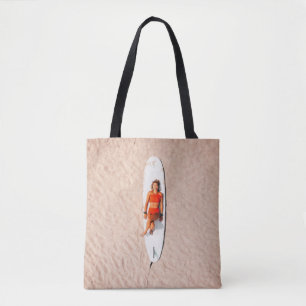 Woman lying on the surfboard tote bag
