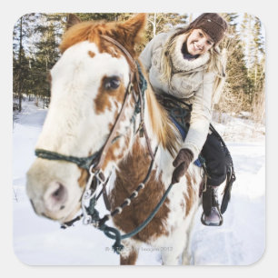 Woman on horse outdoors during winter square sticker