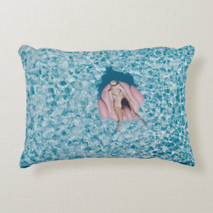 Woman on pink buoy surrounded by body of water in decorative cushion