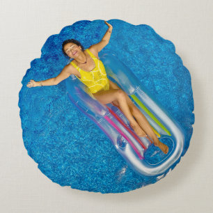 Woman riding on plastic floating buoy on body of w round cushion