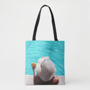 Woman sitting beside swimming pool tote bag