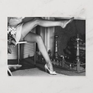 Woman sitting by fireplace B&W Postcard