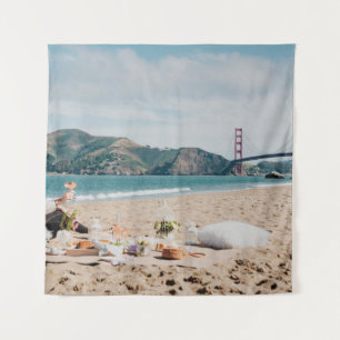 Woman sitting near seashore while looking at Golde Tapestry