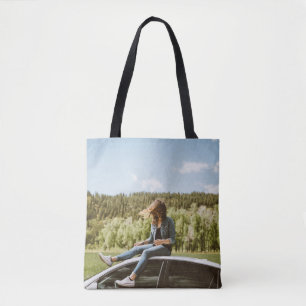 Woman sitting on roof of white sedan tote bag
