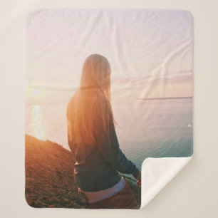 Woman stands near body of water during golden hour sherpa blanket