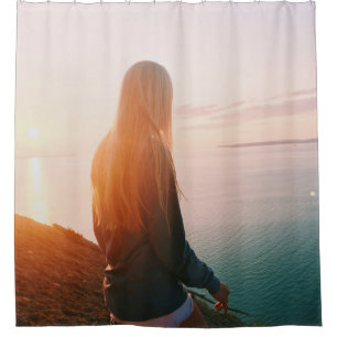 Woman stands near body of water during golden hour shower curtain