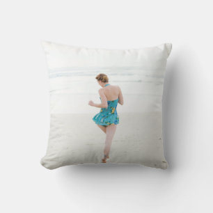 Woman walking on shore near beach cushion
