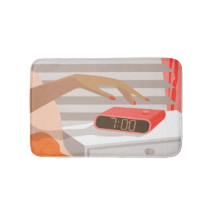 Womans hand pushing on alarm clock snooze button bath mat