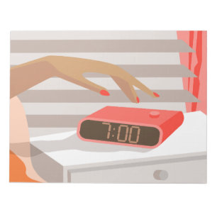 Womans hand pushing on alarm clock snooze button notepad