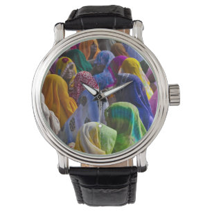 Women in colourful saris gather together watch