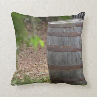 wooden barrel right with green frond left cushion