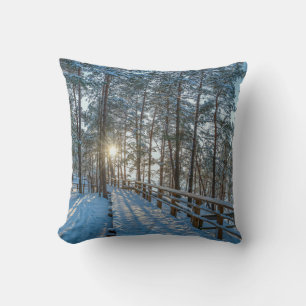 Wooden path across snowy winter forest cushion