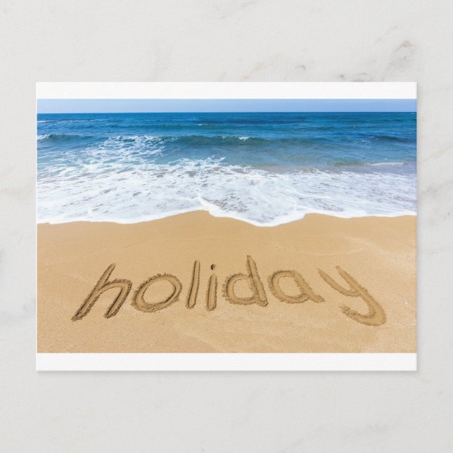 Word holiday written in sand on beach (Front)
