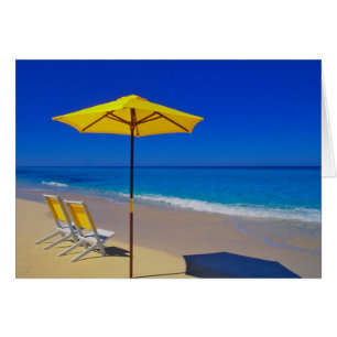 Yellow beach umbrella and chairs on pristine