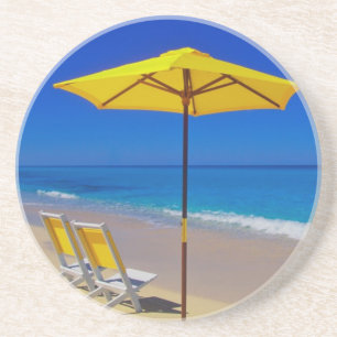 Yellow beach umbrella and chairs on pristine coaster