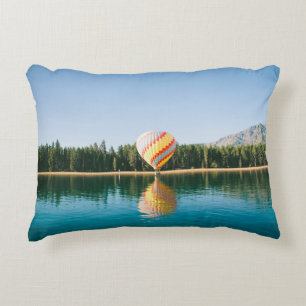 Yellow, red, and blue hot air balloon near trees a decorative cushion