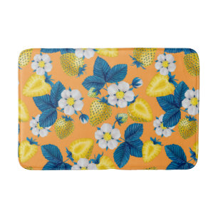 Yellow strawberries on orange bath mat