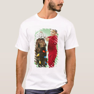 Young boy wrapping Christmas lights around a dog T-Shirt