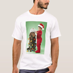 Young boy wrapping Christmas lights around a dog T-Shirt